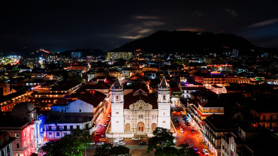 Colorful colonial buildings in Casco Viejo at night with people walking cobblestone streets